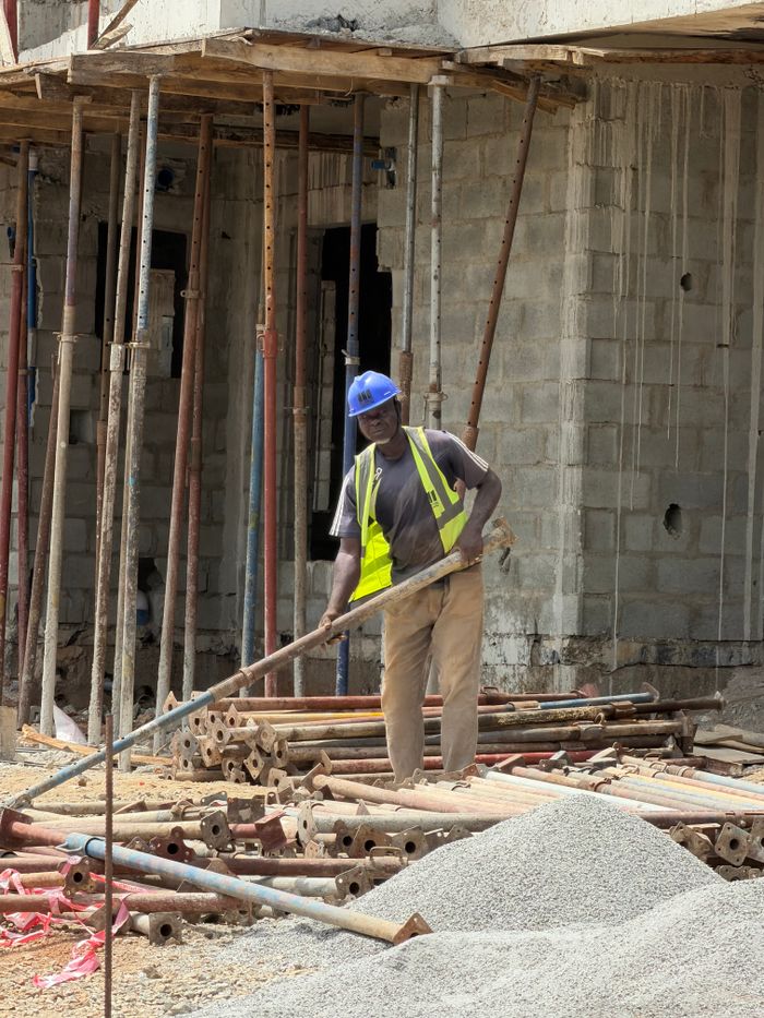 Construction worker operating at a building site, showcasing industry and development.